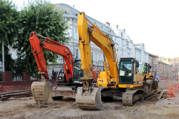 利沃夫的街道上工作的两个现代挖掘机 — 图库照片