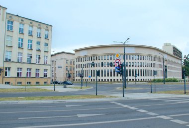 Lodz - Polonya. 22 Temmuz 2019: Lodz 'da modern mimari. Caddenin karşısındaki yaya güzel bir binayla karşıdan karşıya geçiyor. Trafik ışıkları olan boş bir cadde. Trafik ışıkları ve kaldırımlar. Şehir sokağı