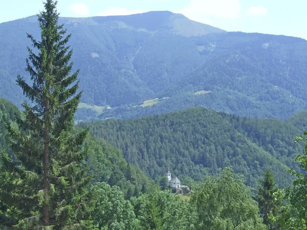 山村风景秀丽 教堂耸立在群山中 山谷之间的山 山村风景 山地全景与乡村教堂 森林中的单一教堂 — 图库照片