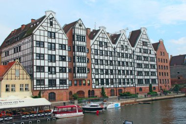 Gdansk - Polonya. 21 Haziran 2019: Gdansk 'ta su kanalının üzerinde duran binaların güzel mimarisi. Gdansk 'ta toprak seti. Şehirdeki bir su kanalı üzerinde modern evler. Polonya şehrinde turistler