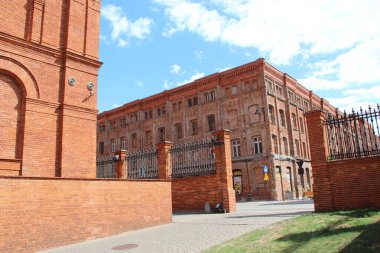 Lodz - Polonya. 17 Ağustos 2019: Kırmızı tuğla fabrikası cephesi. Eski tuğla bina cephesi. Polonya 'nın Lodz şehrinde pencereleri olan eski bir fabrika binası. Polonya 'da eski mimari.