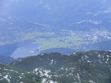 Dağ çayırı. Tepenin kenarındaki orman sınırı. Yeşil ormanlarla kaplı tepeleri olan güzel bir yaz manzarası. Uzakta dağlar var. Dağlık Panorama