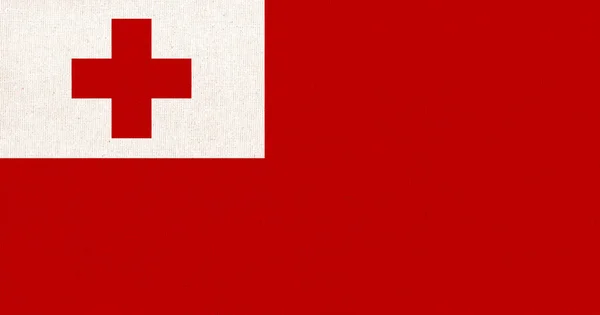 Flag of Tonga. Tonga flag on fabric surface. Fabric texture. National symbol. Country in Oceania. Kingdom of Tonga