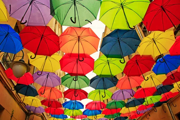 Colored umbrellas hanging at top. Set of different umbrellas. Local landmark. Cafe decoration in Lodz. Multicolored umbrella. Street decoration. Place of interest. Bold colors