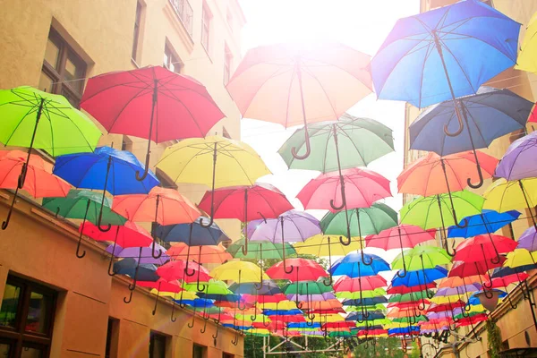 Colored umbrellas hanging at top. Set of different umbrellas. Local landmark. Cafe decoration in Lodz. Multicolored umbrella. Street decoration. Place of interest. Bold colors