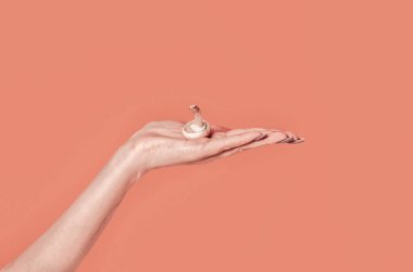 Basit bir minimalist sonbahar konsepti. Güzel bir kadının eli avucunda kahverengi bir mantar tutuyor. Tawny turuncu arka plan. Basit modern doğa geçmişi. Asgari doğa mevsimlik kavramı.