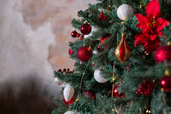 लिविंग रूम में खजूर के पेड़ पर उत्सव की गेंदों की क्लोजअप फोटो। सफेद, लाल क्रिसमस सजावट पेड़ पर लटका हुआ. सजावटी क्रिसमस पेड़ के साथ शीतकालीन समारोहों के लिए पृष्ठभूमि — स्टॉक फ़ोटो, इमेज
