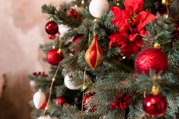 リビングルームのモミの木の上のお祝いのボールのクローズアップ写真。白、赤クリスマスの装飾は木にかかっています。装飾されたクリスマスツリーと冬のお祝いのための背景 — ストック写真