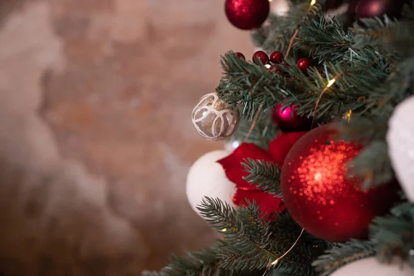 Foto di primo piano di palle festive su abete in soggiorno. bianco, rosso decorazioni natalizie appese su tree.ackground per le celebrazioni invernali con albero di Natale decorato — Foto Stock