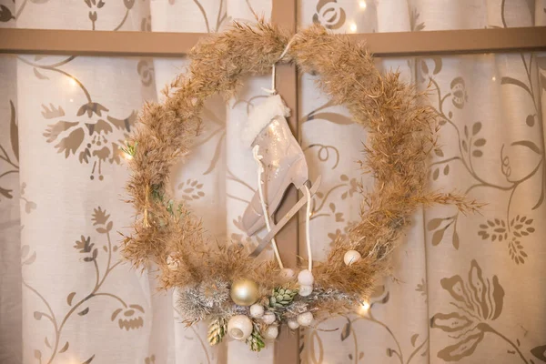 古いヴィンテージの板張りの木の背景に金、白いボール、ライト、ピネコンで飾られた緑のクリスマスリース、素朴なスタイル。冬の休日のための創造的な手作り花輪. — ストック写真