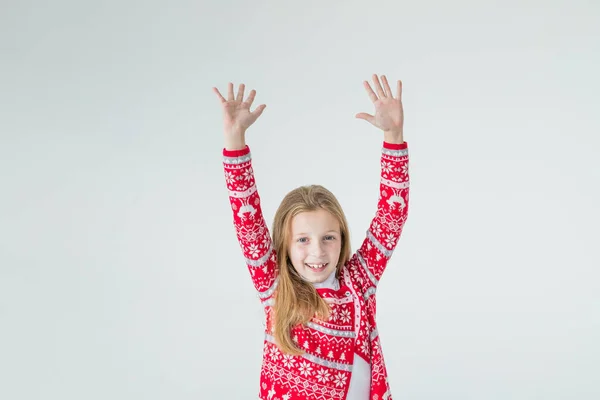 Porträtt av glad flicka dans hålla händerna över huvudet bär jul tröja isolerad på vit bakgrund.Jul och nyårskoncept.Positiv flicka i röd tröja.Julstämning. — Stockfoto