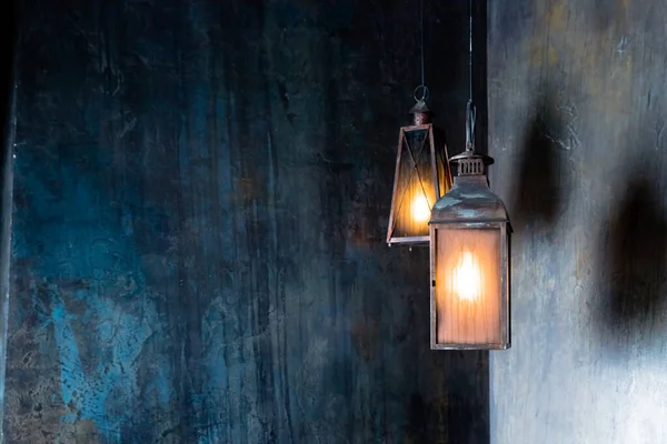 Vintage Lantern hangs in the night.hanging iron black lanterns with big glasses burning in the dark of the night.decoration and interior concept — Stock Photo, Image