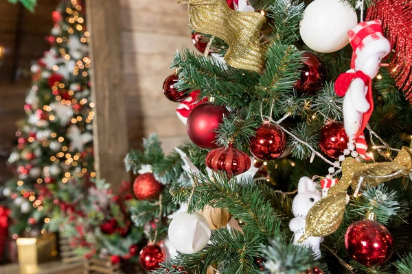 Primer plano de la bola roja y blanca que cuelga de una rama de Navidad decorada. fondo abstracto con luces desenfocadas.Habitación decorada para el nuevo año y la Navidad. —  Fotos de Stock