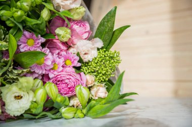 Bir buket gül, papatya, lisianthus, kasımpatı, masada açılmamış tomurcuklar. Beyaz frezyalar, karanfiller. Çiçek arkaplan. Tatil hediyesi. Çiçekçi. Taze kesilmiş çiçek getirdim..