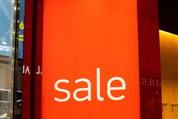 Sinal de venda na entrada da loja de roupas, grandes painéis vermelhos com palavras brancas. Oferta de desconto sazonal na loja. Descontos e conceito de sexta-feira preta.Placa de publicidade — Fotografia de Stock