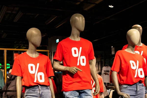 Tres modelos maniquí maniquí usando camisas rojas con texto blanco por ciento sign.sale de moda shop.sale, concepto de compras —  Fotos de Stock