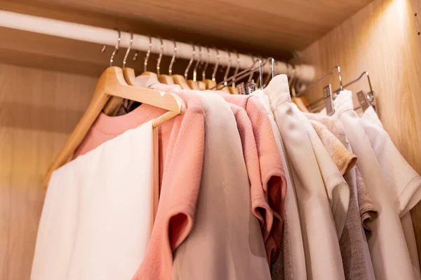 Κρεμάστρες με διαφορετικά ρούχα στην ντουλάπα ντουλάπα.πουκάμισα και φόρεμα κρέμεται σε ράγα σε ξύλινη ντουλάπα. μινιμαλιστικό μοντέρνο σκανδιναβικό λευκό ξύλο με τα πόδια στην ντουλάπα με ντουλάπα σε ουδέτερα μπεζ χρώματα — Φωτογραφία Αρχείου