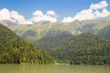 Yazın Doğa Vadisi 'nde güzel bir dağ gölü. Ritsa Gölü. Gürcistan 'ın Abhazya kentindeki Kafkasya Dağları' ndaki Ritsa Gölü 'nün etrafı karışık dağ ormanları ve subalpin çayırlarıyla çevrilidir..
