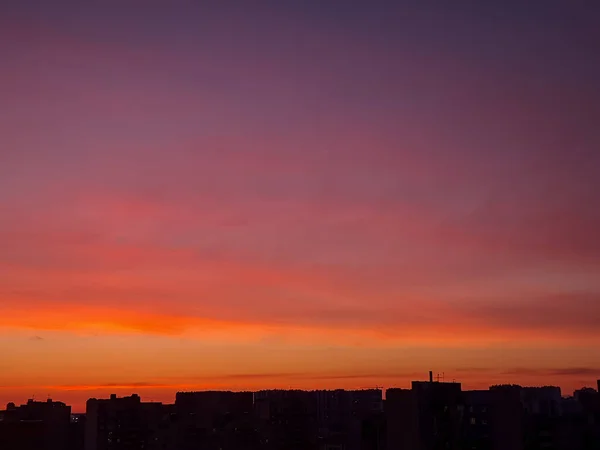 Zachód słońca tło z cudownym czerwonym, złotym, żółtym niebem, Niesamowity fioletowy i pomarańczowy niebo w wieczorze podczas zachód słońca nad mieście.Dramatyczny zachód słońca niebo z chmurami — Zdjęcie stockowe