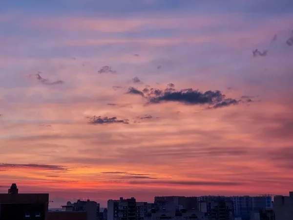 Coucher de soleil avec un magnifique ciel rouge, doré, jaune, Incroyable ciel violet et orange en soirée pendant que le soleil se couche au-dessus de la ville. — Photo