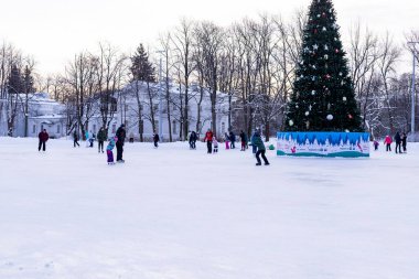 Omsk, Rusya, 2 Ocak 2022 Kış Buz Pisti. Kaykaylı insanlar buzda kayıyorlar. Kış tatillerinde aktif aile sporu. Okul spor kulüpleri. Sağlıklı yaşam tarzı ve kış sporları konsepti.