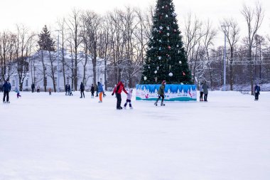 Omsk, Rusya, 2 Ocak 2022 Kış Buz Pisti. Kaykaylı insanlar buzda kayıyorlar. Kış tatillerinde aktif aile sporu. Okul spor kulüpleri. Sağlıklı yaşam tarzı ve kış sporları konsepti.