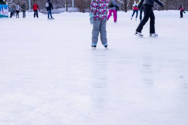 Omsk, Rusya, 2 Ocak 2022 Kış Buz Pisti. Kaykaylı insanlar buzda kayıyorlar. Kış tatillerinde aktif aile sporu. Okul spor kulüpleri. Sağlıklı yaşam tarzı ve kış sporları konsepti.