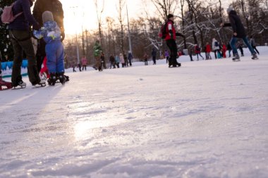 Omsk, Rusya, 2 Ocak 2022 Kış Buz Pisti. Kaykaylı insanlar buzda kayıyorlar. Kış tatillerinde aktif aile sporu. Okul spor kulüpleri. Sağlıklı yaşam tarzı ve kış sporları konsepti.
