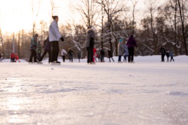 Omsk, Rusya, 2 Ocak 2022 Kış Buz Pisti. Kaykaylı insanlar buzda kayıyorlar. Kış tatillerinde aktif aile sporu. Okul spor kulüpleri. Sağlıklı yaşam tarzı ve kış sporları konsepti.