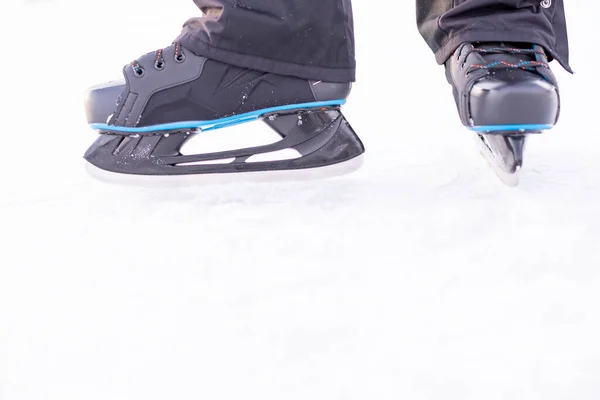 Mans Hockeyschlittschuhe auf Eis Hintergrund. Die Leute skaten auf der Eisbahn. Unterhaltung am Wochenende im Winter im Freien. Outdoor-Aktivitäten am Wintertag. — Stockfoto