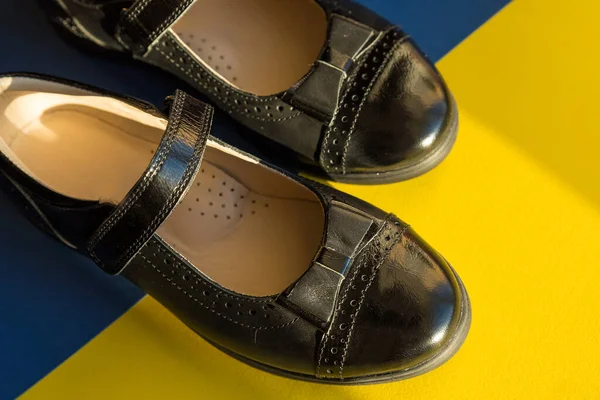 Нові шкіряні чорні туфлі ізольовані на яскравому тлі, готуються до повернення до шкільної концепції.дитячі класичні шкіряні лакові шкільні туфлі для дівчинки, шкільна форма — стокове фото