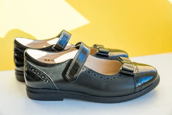 Нові шкіряні чорні туфлі ізольовані на яскравому тлі, готуються до повернення до шкільної концепції.дитячі класичні шкіряні лакові шкільні туфлі для дівчинки, шкільна форма — стокове фото