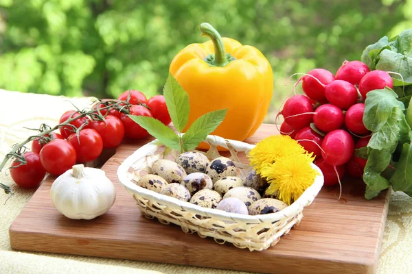 Bir kompozisyon bıldırcın yumurtası ve ahşap üzerine taze sebze (biber, sarımsak, turp ve kiraz domates) — Stok fotoğraf