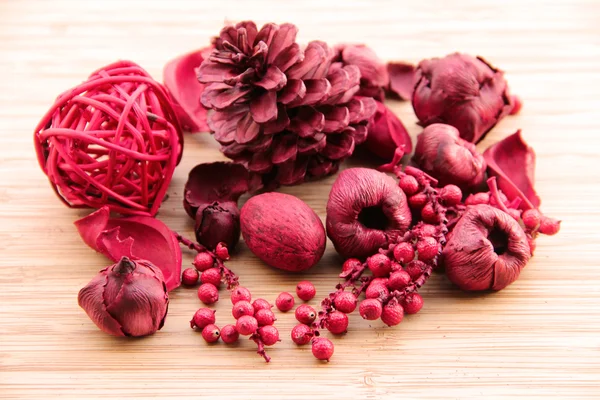 A red berry and fruit potpourri composition against a wooden background — Stock Photo, Image