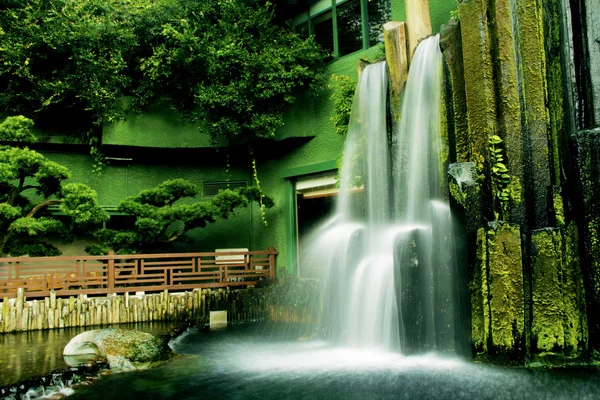 Beautiful waterfall in Chinese Classical Garden called Nan Lian in Hong Kong situated on the Kowloon Island. Blurred motion.