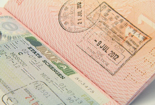 Foto de perto de visto Schengen e visto de Hong Kong em um passaporte — Fotografia de Stock