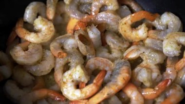 Büyük karidesler pişiriyorum. Kral karidesler tavada kızarır.