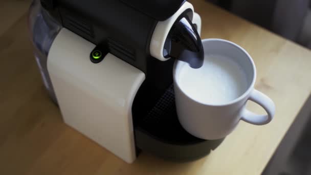 Чашка кофе с молочной пеной, кофеварка — стоковое видео