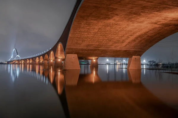 Reflection in the water of a bridge across a river 