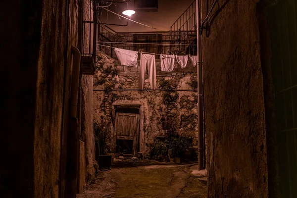 An alley at night in an ancient village in Italy where laundry hangs to dry