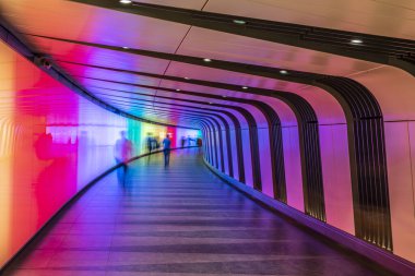 A pedestrian tunnel with shadows, lines and bright colors