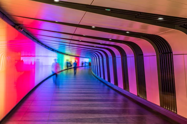 A pedestrian tunnel with shadows, lines and bright colors