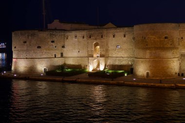 Taranto, Apulia, İtalya: Geceleri deniz üzerindeki şatonun manzarası