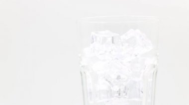 Bardakta buzlu kola. Kola Gazozu yakın plan. Beyaz arkaplanda dönen kola bardağı.