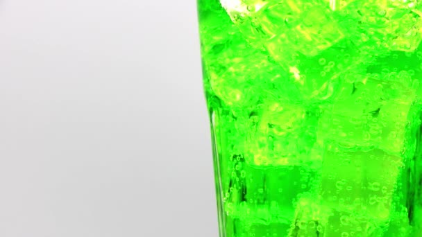 유리에 얼음을 녹색빛나는 위에서 마시는 — 비디오