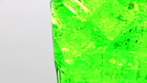 유리에 얼음을 녹색빛나는 청록색 물컵이 — 비디오