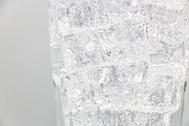 Soda köpüklü su, beyaz zemin üzerinde buzlu cam.. 