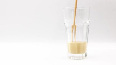 Kahve aromalı sütü beyaz arka planda bir bardağa doldur..