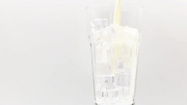 Sütü beyaz arka planda dönen bir bardağa dökün..