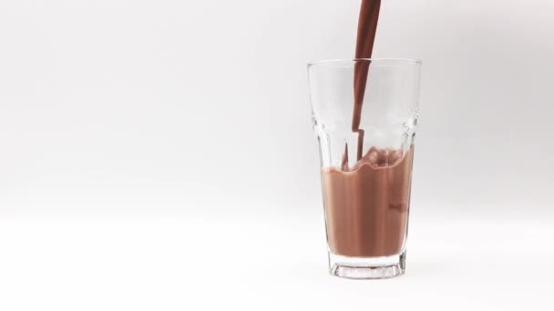 Ρίξτε Σοκολάτα Αρωματισμένο Γάλα Ένα Ποτήρι Λευκό Φόντο — Αρχείο Βίντεο